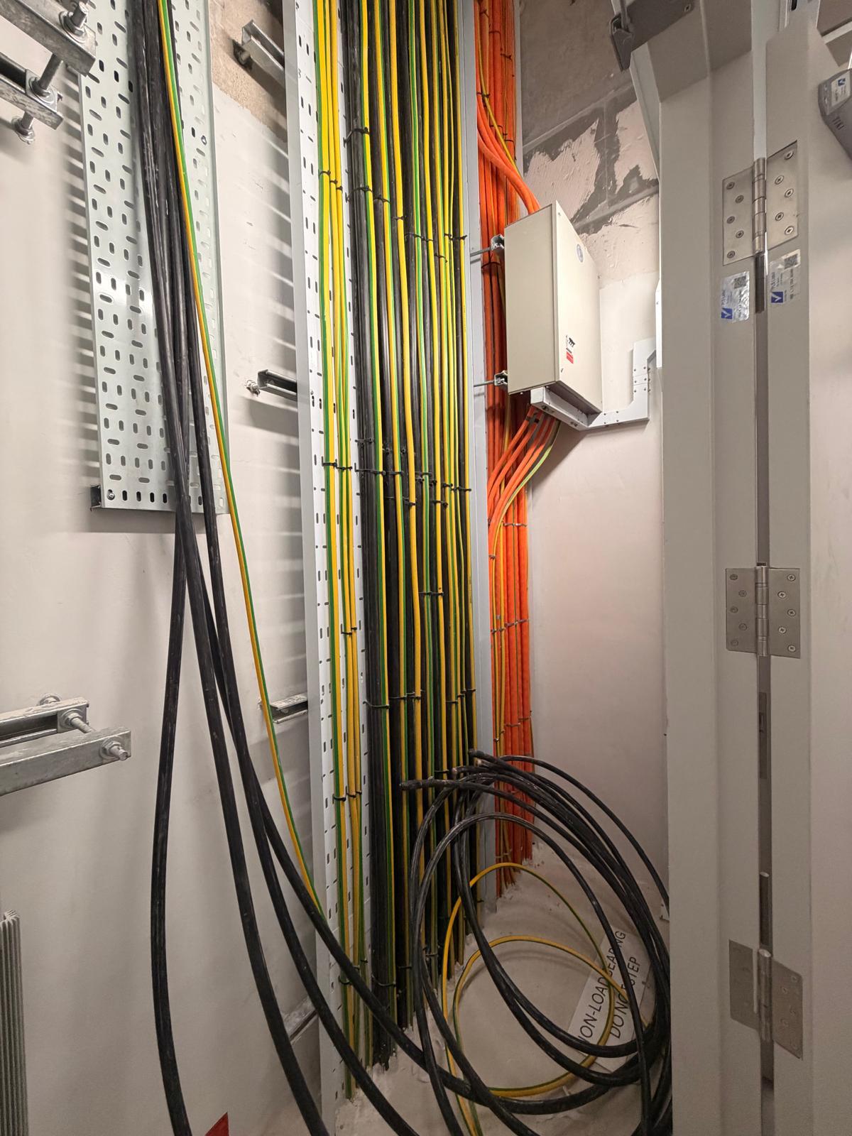 Electrical riser with sub distribution board, cable tray and orange fire-rated cabling installed by Shanteck SG Engineering