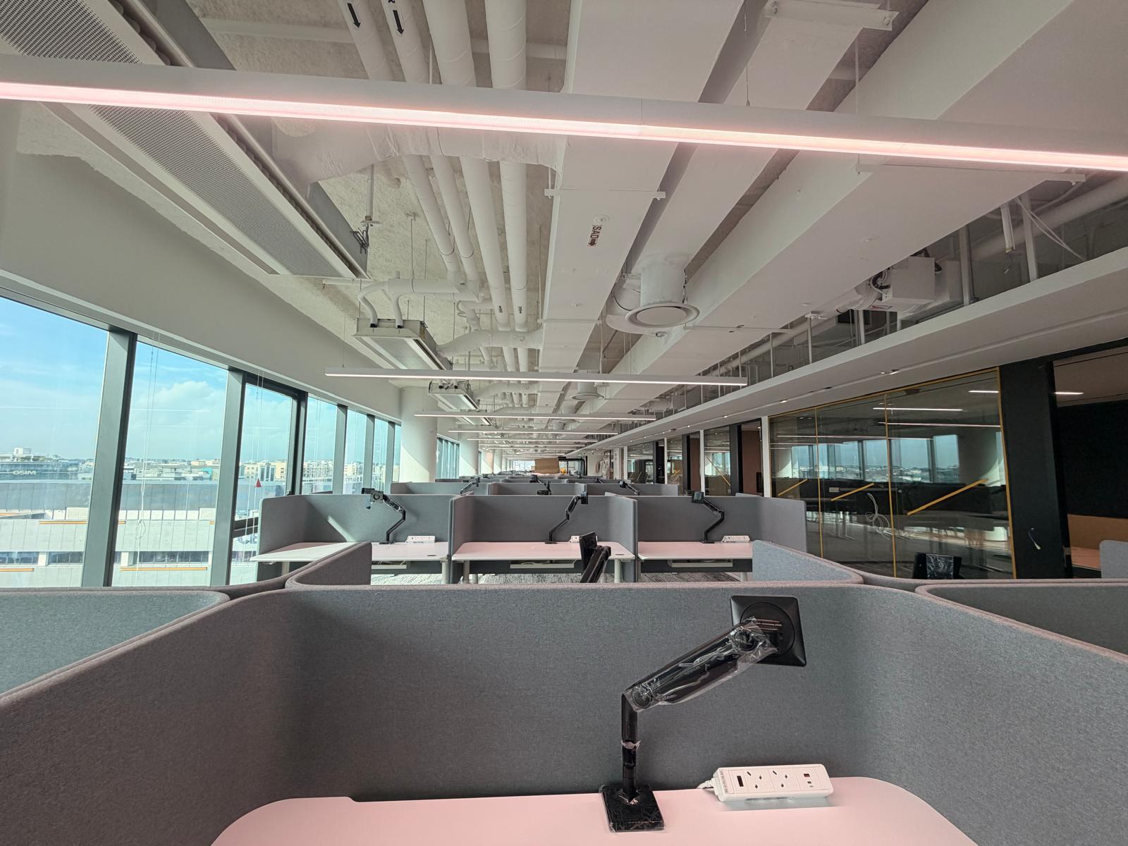 Open office workstations with desk power strips, data points and suspended linear LED lighting — Singapore office electrical fit-out
