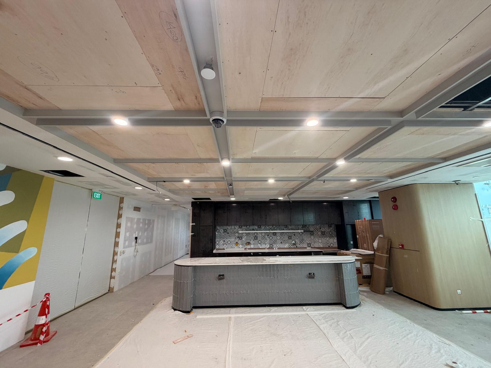 Office pantry with timber ceiling, downlights, CCTV dome camera and exit signage installed by Shanteck SG Engineering