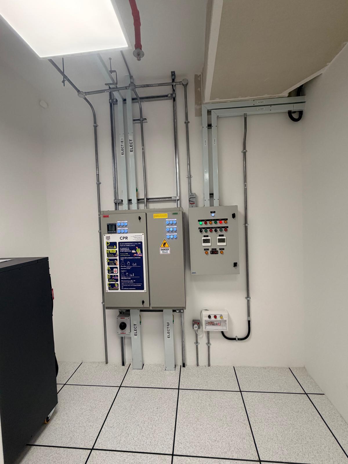 Server room electrical distribution boards with ACMV control panel, conduit risers and isolator — licensed electrical installation Singapore