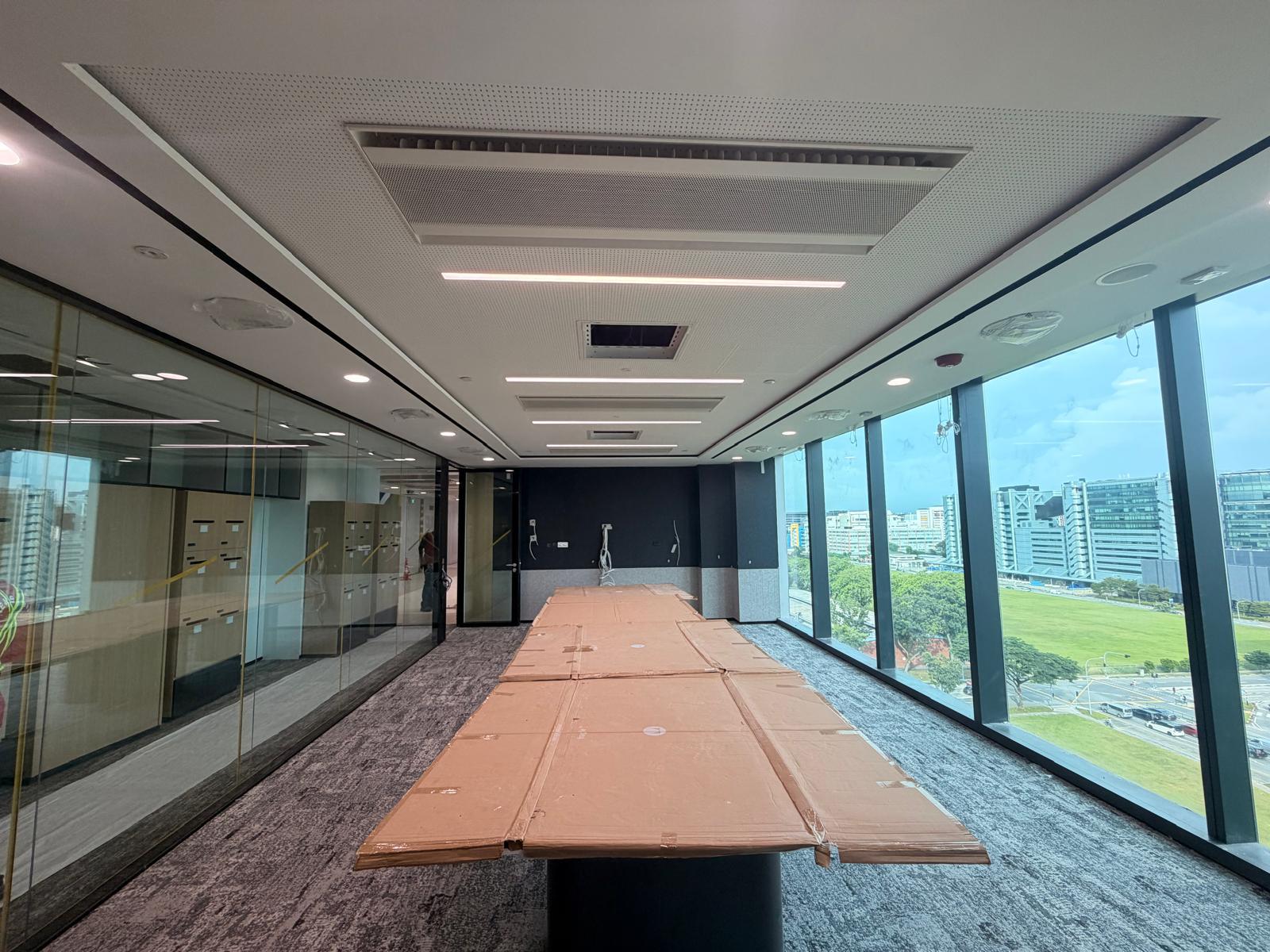 Boardroom with acoustic perforated ceiling, linear LED lighting, sprinklers and AC diffusers — Singapore office fit-out electrical works