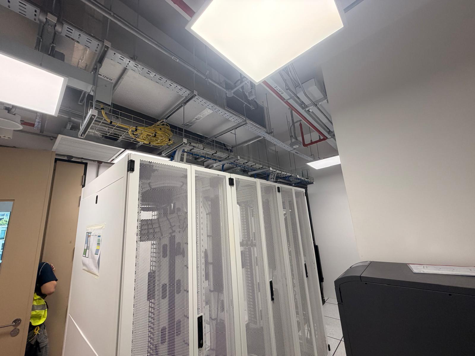 Server room cabinets with overhead cable trays, fibre and Cat6 containment above racks in a Singapore data centre room